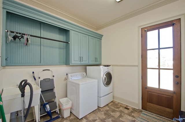 washroom with ornamental molding, cabinet space, a wealth of natural light, and washer and clothes dryer