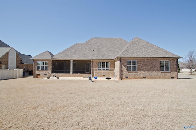 rear view of property with brick siding, fence, roof with shingles, a sunroom, and crawl space