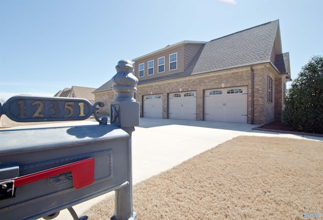 view of front of home with brick siding, driveway, and a shingled roof