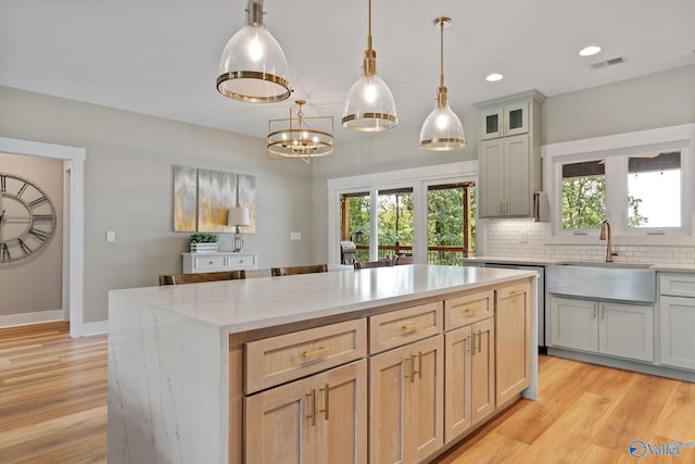 kitchen featuring light wood-type flooring, a healthy amount of sunlight, and sink