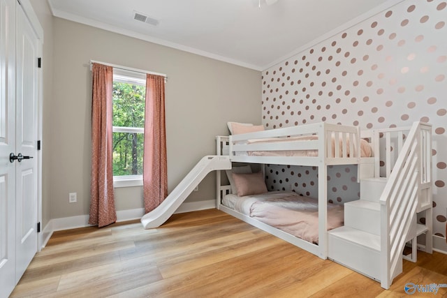 bedroom featuring crown molding and wood-type flooring