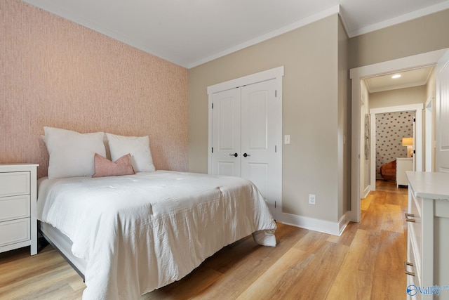 bedroom featuring light hardwood / wood-style floors, a closet, and crown molding