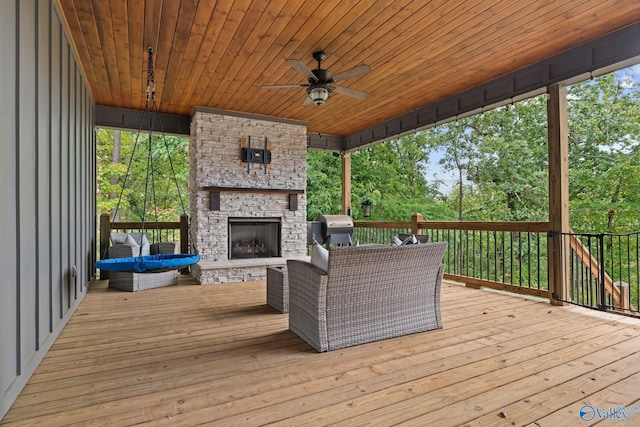 deck featuring an outdoor living space with a fireplace and ceiling fan