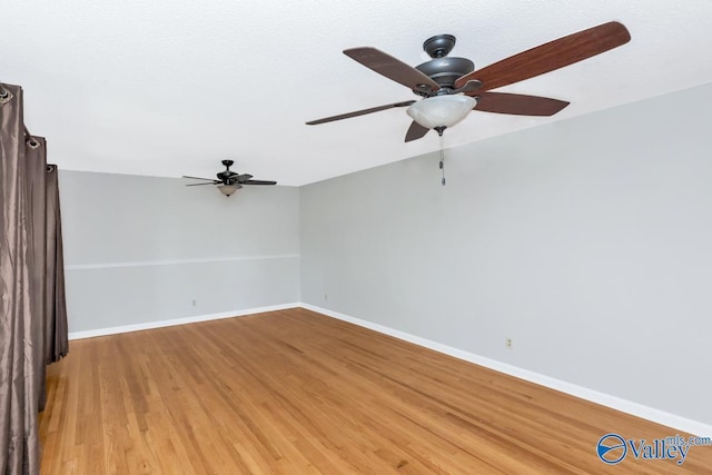 empty room with hardwood / wood-style floors and ceiling fan