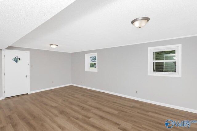 interior space with crown molding, hardwood / wood-style floors, and a textured ceiling