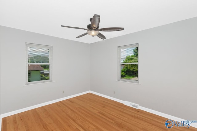 unfurnished room with ceiling fan, wood-type flooring, and plenty of natural light