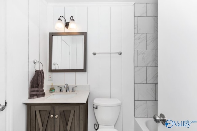 full bathroom featuring tiled shower / bath combo, vanity, and toilet