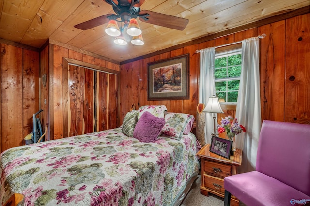 carpeted bedroom with wood walls, wooden ceiling, and ceiling fan