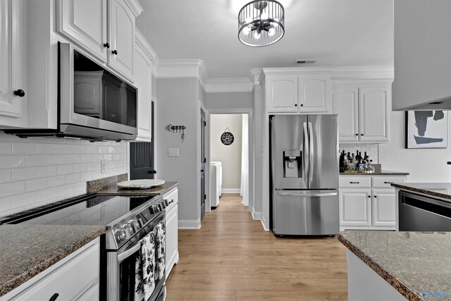 17092 Obsidian Cir, Athens, AL 35613 - kitchen featuring appliances with stainless steel finishes, white cabinets, dark stone countertops, and crown molding
