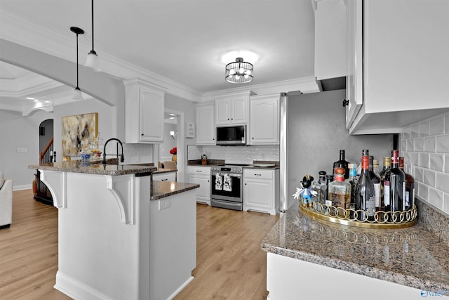 17092 Obsidian Cir, Athens, AL 35613 - kitchen featuring stainless steel appliances, a peninsula, white cabinets, a breakfast bar, and arched walkways