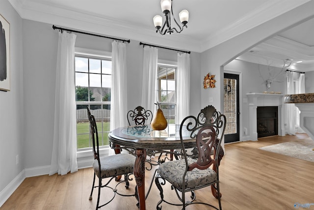 17092 Obsidian Cir, Athens, AL 35613 - dining area featuring ornamental molding, light wood-style flooring, a fireplace, baseboards, and a chandelier