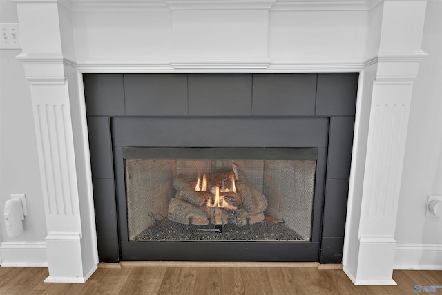 17092 Obsidian Cir, Athens, AL 35613 - detailed view of a lit fireplace, wood finished floors, and baseboards