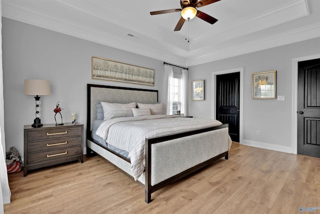 17092 Obsidian Cir, Athens, AL 35613 - bedroom featuring a tray ceiling, light wood-style flooring, crown molding, a ceiling fan, and baseboards