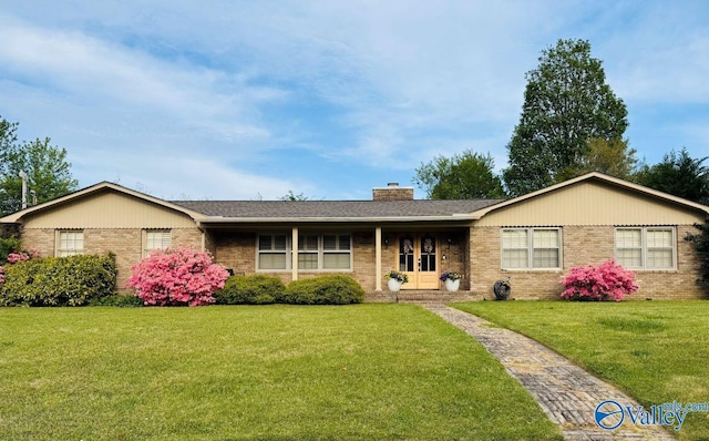 ranch-style home with a shingled roof, a chimney, a front lawn, and brick siding