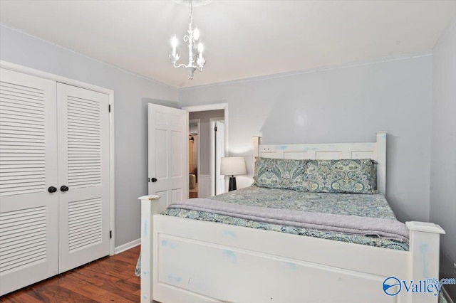 bedroom with a closet, dark wood-style floors, and a chandelier