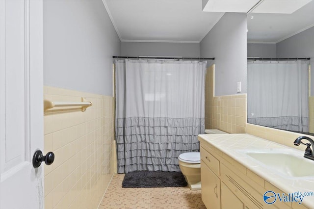 full bath with crown molding, vanity, toilet, tile walls, and a wainscoted wall