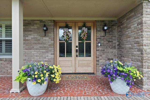 view of exterior entry with french doors and brick siding