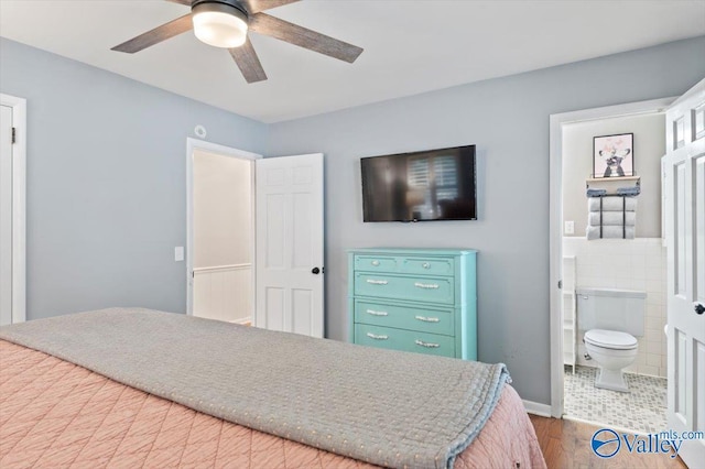 bedroom featuring connected bathroom, ceiling fan, and wood finished floors