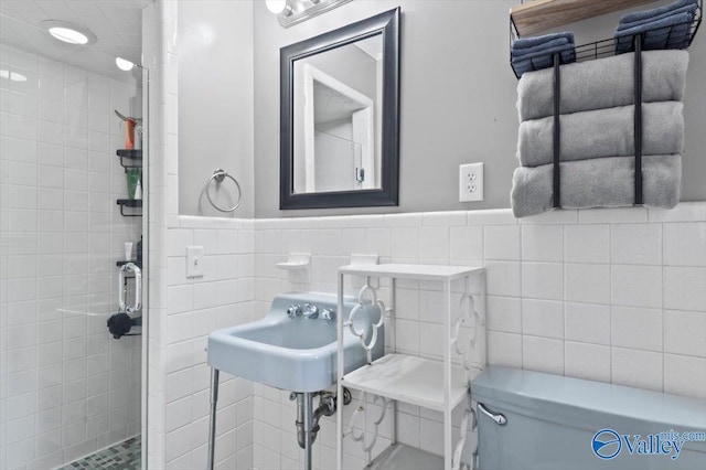 full bath featuring wainscoting, tile walls, and a stall shower