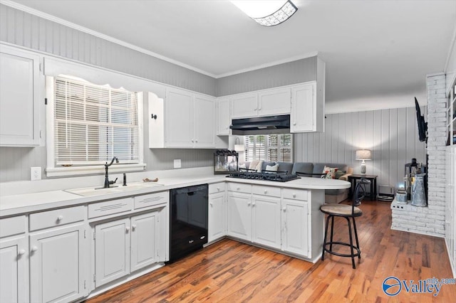 kitchen with a sink, black appliances, a peninsula, under cabinet range hood, and white cabinetry