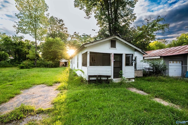 view of front of property featuring a front lawn, an outdoor structure, and a garage