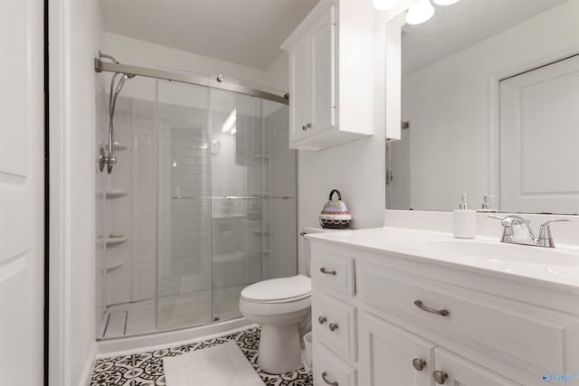 bathroom with vanity, tile patterned flooring, a shower stall, and toilet