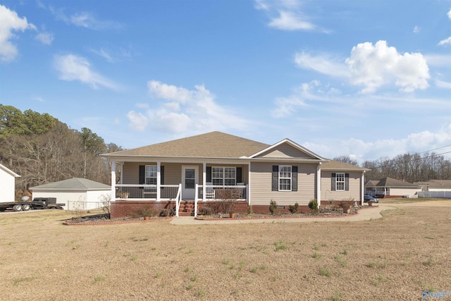 view of front of house featuring covered porch, roof with shingles, and a front lawn