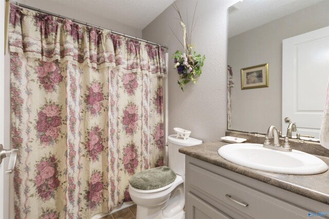 bathroom with curtained shower, tile patterned flooring, vanity, and toilet