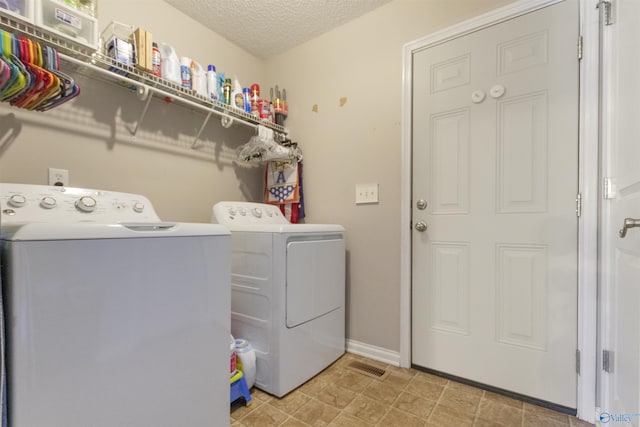 washroom with visible vents, a textured ceiling, laundry area, independent washer and dryer, and baseboards