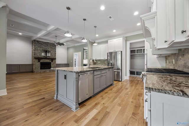 78 Mcmullen Ln SE, Gurley, AL 35748 - kitchen featuring appliances with stainless steel finishes, a sink, a fireplace, open floor plan, and decorative backsplash