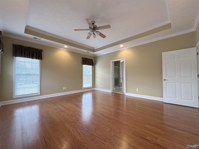 unfurnished room featuring hardwood / wood-style flooring, ceiling fan, and a raised ceiling