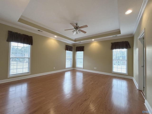 spare room with hardwood / wood-style flooring, ceiling fan, a tray ceiling, and crown molding