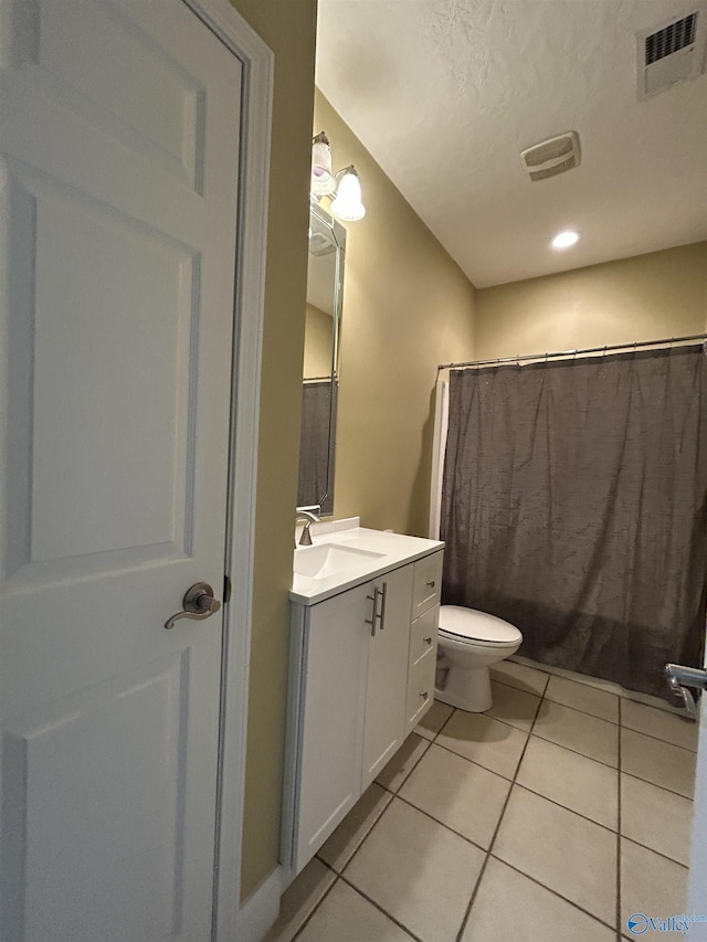 bathroom with curtained shower, vanity, toilet, tile patterned floors, and a textured ceiling