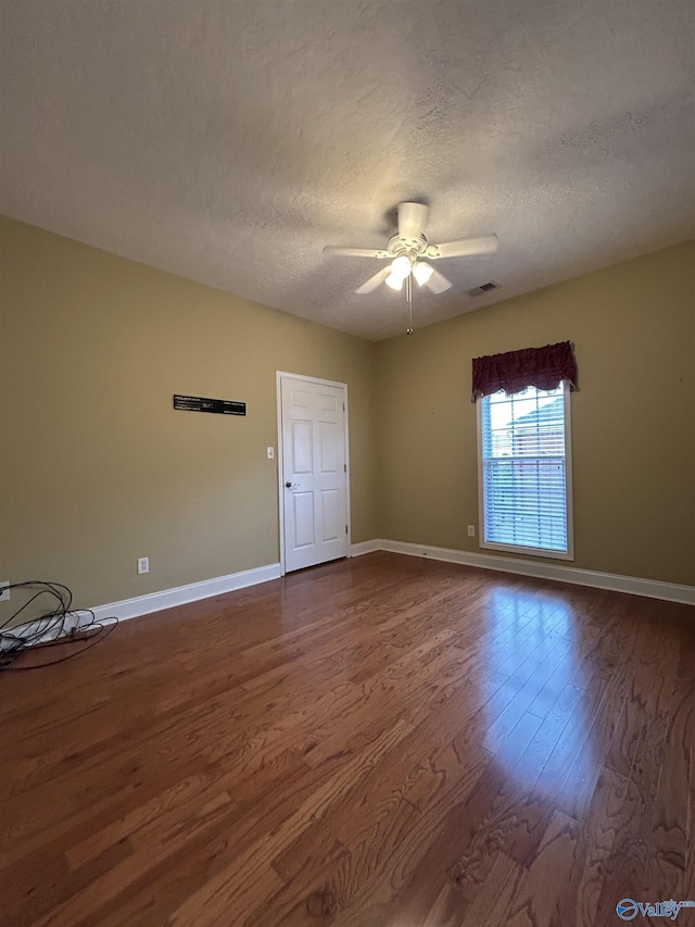 spare room with a textured ceiling, wood-type flooring, and ceiling fan