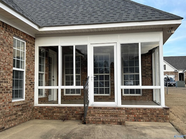 view of property exterior featuring a sunroom and a patio area