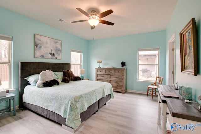 bedroom featuring visible vents, ceiling fan, baseboards, and light wood-style floors