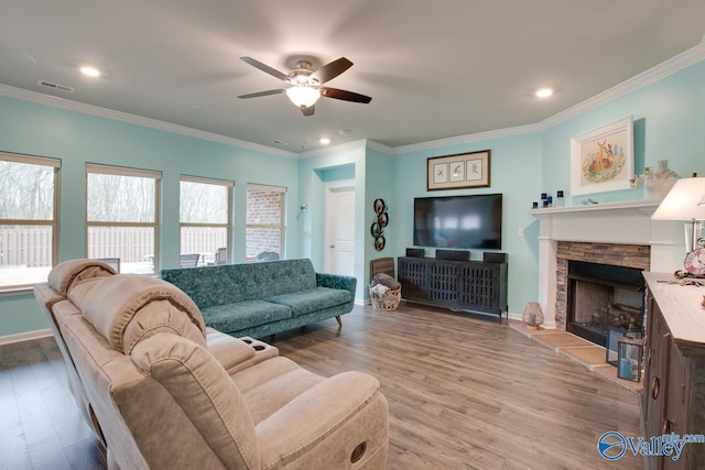 living area featuring ornamental molding, a ceiling fan, and wood finished floors