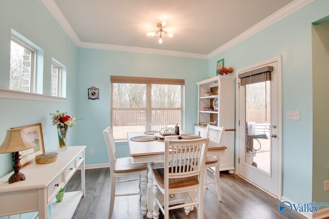 dining area with wood finished floors, baseboards, and ornamental molding