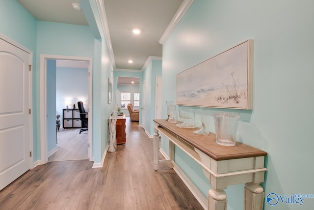 hallway featuring recessed lighting, crown molding, baseboards, and wood finished floors