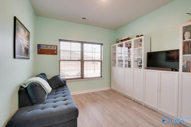 living area featuring visible vents, light wood-type flooring, and baseboards