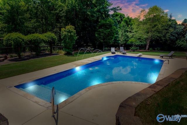 outdoor pool with a patio and a lawn