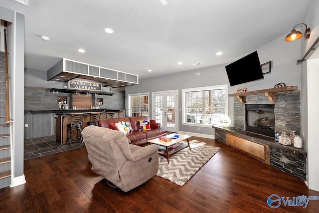 living area featuring a bar, hardwood / wood-style floors, a fireplace, and recessed lighting