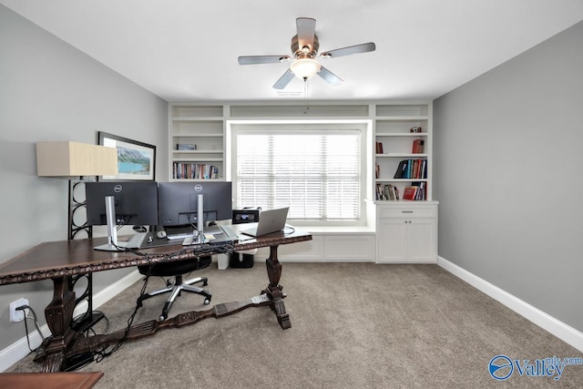 office featuring built in shelves, light colored carpet, ceiling fan, and baseboards