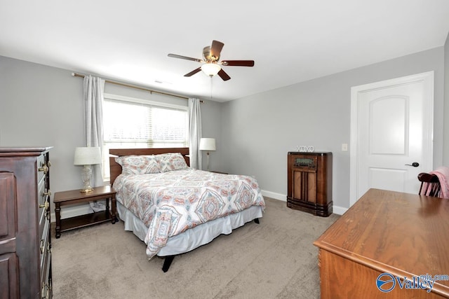 bedroom featuring light carpet, baseboards, and a ceiling fan