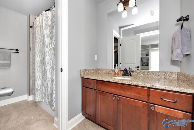 bathroom featuring curtained shower, visible vents, vanity, baseboards, and tile patterned floors