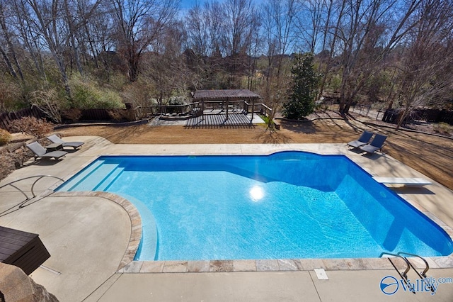 view of pool with a diving board, a patio area, fence, and a fenced in pool