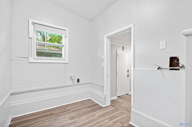 empty room featuring baseboards, ornamental molding, and wood finished floors