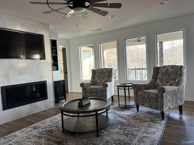 interior space with dark wood-type flooring, ceiling fan, and a fireplace