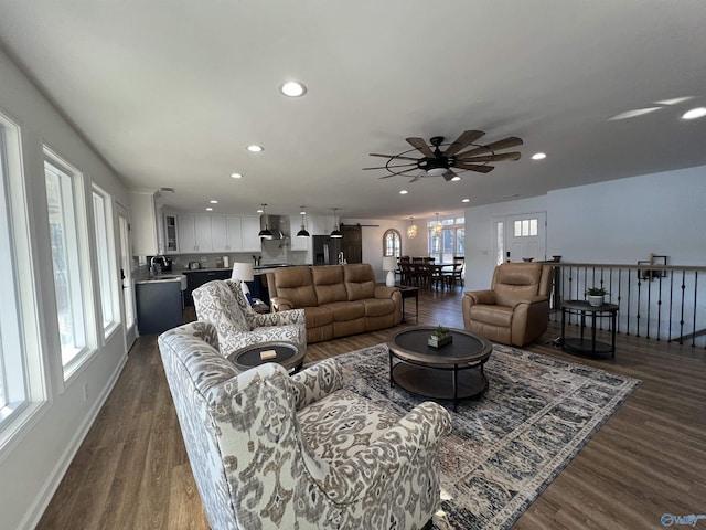 living room featuring a healthy amount of sunlight, dark hardwood / wood-style floors, and ceiling fan