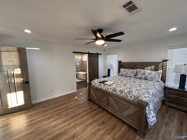 bedroom featuring dark wood-type flooring, ceiling fan, and a barn door